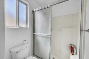 Full bath with a shower stall and toilet