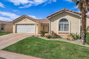 Mediterranean / spanish-style house with stucco siding, a tile roof, a front lawn, and an attached garage