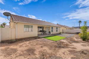 Back of property with a patio, stucco siding, a tiled roof, and a fenced backyard