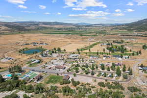 Aerial view of property and surrounding area featuring a mountainous background and rural landscape