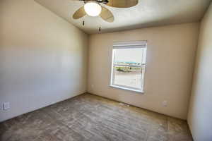 Carpeted spare room featuring ceiling fan