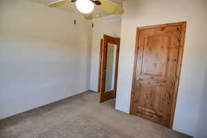 Unfurnished bedroom with carpet flooring and a ceiling fan