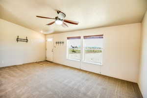 Carpeted empty room with a ceiling fan