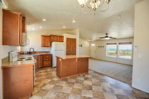 Kitchen featuring vaulted ceiling, a breakfast bar area, white appliances, a kitchen island, and brown cabinets