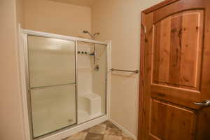 Full bath with a stall shower and baseboards