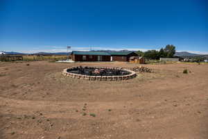 View of yard with a storage shed, a mountain view, a fire pit, and a view of countryside