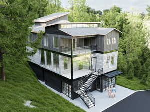 Back of property featuring a balcony, stairway, a patio, and a yard