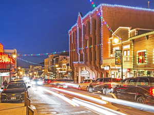 View of asphalt street featuring street lighting and sidewalks