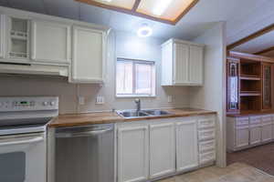 Kitchen with white range with electric cooktop, dishwasher, white cabinets, under cabinet range hood, and wood counters