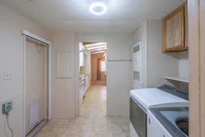 Kitchen featuring light countertops, a heating unit, independent washer and dryer, and white range oven