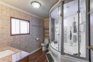 Bathroom featuring tile walls, vanity, a shower stall, dark wood-type flooring, and a jetted tub