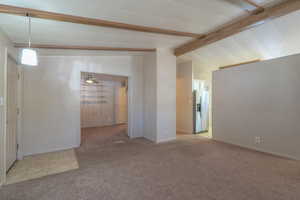 Carpeted spare room featuring baseboards