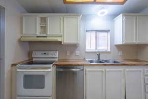 Kitchen featuring white range with electric cooktop, stainless steel dishwasher, white cabinetry, and under cabinet range hood