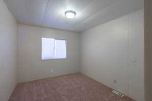 Unfurnished room with carpet and a textured ceiling