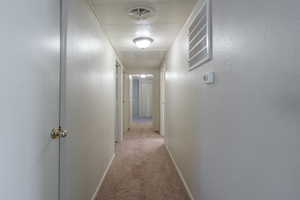 Hall with light carpet and a textured wall