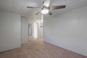 Spare room with light carpet and ceiling fan