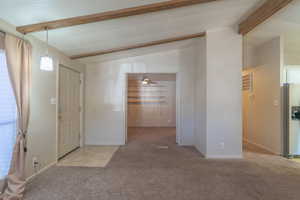 Foyer with light colored carpet and baseboards