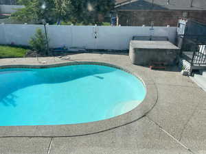 View of swimming pool with a hot tub
