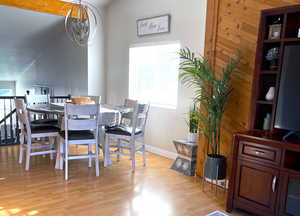 Dining space with light wood-type flooring and wooden walls