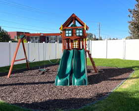 View of jungle gym with a fenced backyard