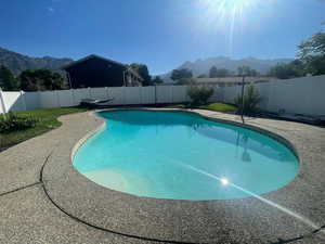View of swimming pool featuring a mountain view, a fenced backyard, and a patio