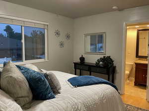 Bedroom featuring light wood finished floors and connected bathroom