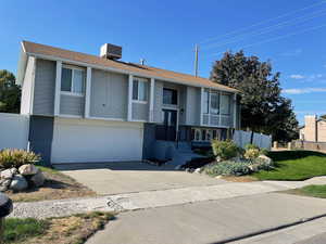 Split foyer home with brick siding, concrete driveway, and an attached garage