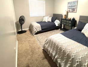 Bedroom with light colored carpet and baseboards