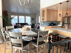 Dining space with recessed lighting, light wood-style flooring, a chandelier, and lofted ceiling