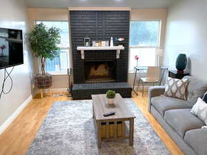 Living room featuring light wood-type flooring and a brick fireplace