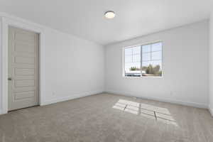 Empty room with light carpet and baseboards