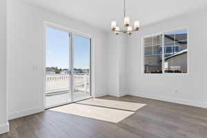 Unfurnished dining area with hardwood / wood-style flooring and a chandelier