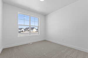 Spare room featuring light colored carpet and a residential view