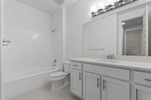Full bath featuring  shower combination, vanity, and light tile patterned floors