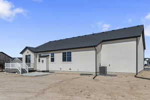 Rear view of property featuring a patio area, a shingled roof, stucco siding, and a deck