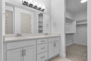 Bathroom featuring a spacious closet and double vanity