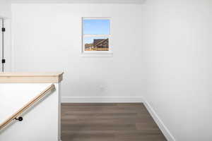 Unfurnished bedroom with dark wood finished floors and baseboards