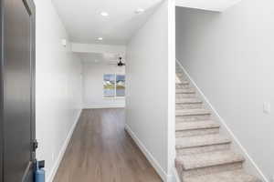 Stairway with wood finished floors, recessed lighting, and a ceiling fan