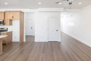 Kitchen with recessed lighting, stainless steel appliances, light countertops, ceiling fan, and dark wood-type flooring