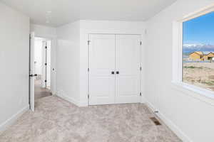 Unfurnished bedroom with light carpet, a closet, and recessed lighting