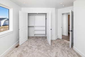 Unfurnished bedroom featuring light colored carpet, a closet, and recessed lighting