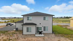 Back of house featuring roof with shingles, stucco siding, and a residential view