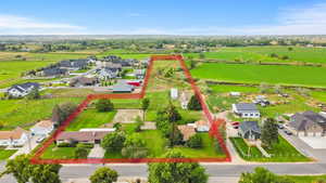 Overview of rural landscape featuring nearby suburban area and property parcel outlined