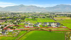 Aerial view of residential area with a mountain backdrop and property parcel outlined