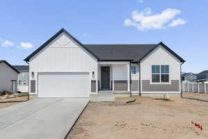 Modern farmhouse featuring covered porch, board and batten siding, driveway, an attached garage, and roof with shingles