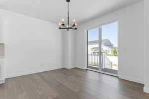 Unfurnished dining area with a chandelier and light wood-type flooring