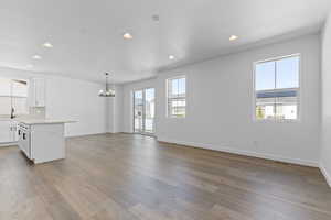 Unfurnished living room featuring recessed lighting, light wood finished floors, and a chandelier