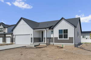 Modern farmhouse featuring board and batten siding, roof with shingles, driveway, covered porch, and an attached garage