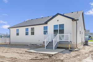 Rear view of house featuring roof with shingles