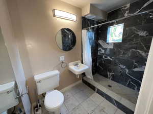 Bathroom with a stall shower and tile patterned floors